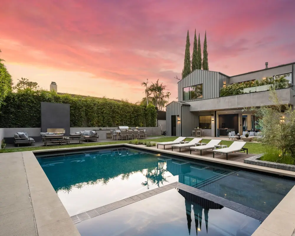 Backyard pool with sunset background.